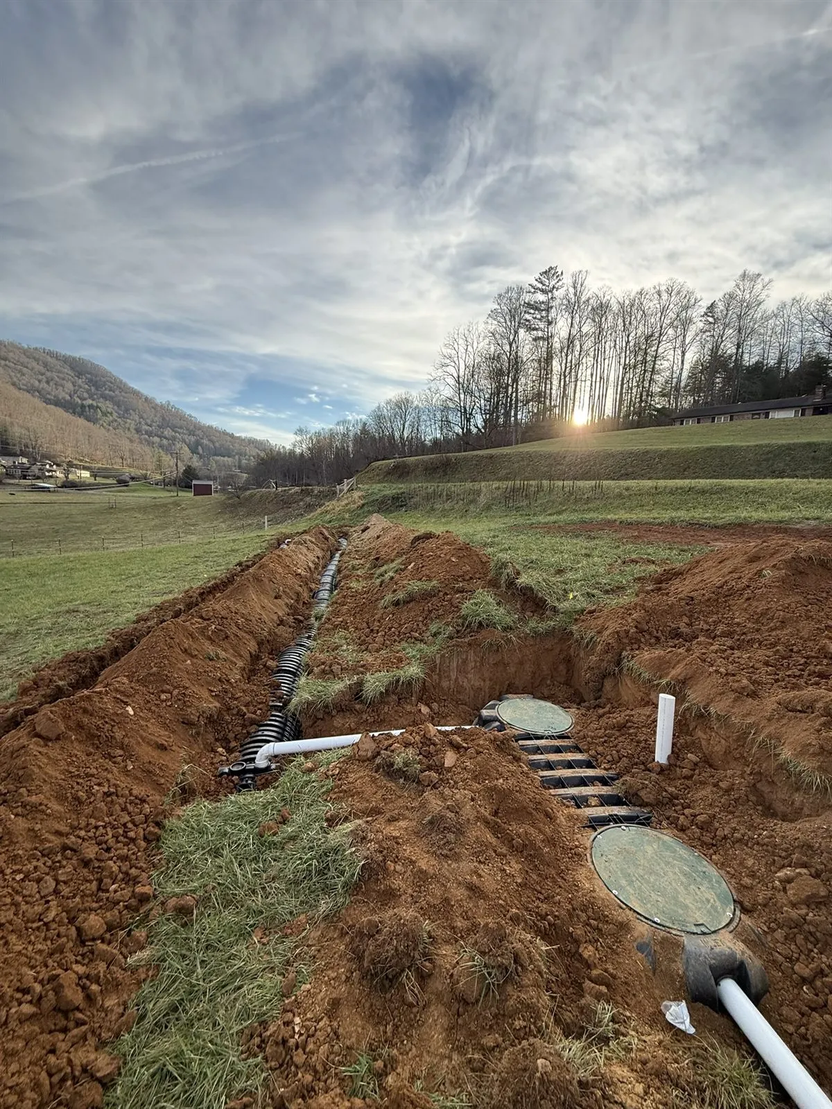 Graded drainage swale carrying runoff across open ground near Marshall, NC