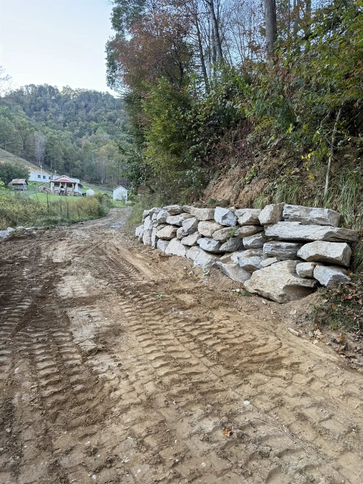 Boulder retaining wall along a graded driveway on a steep lot near Banner Elk, NC