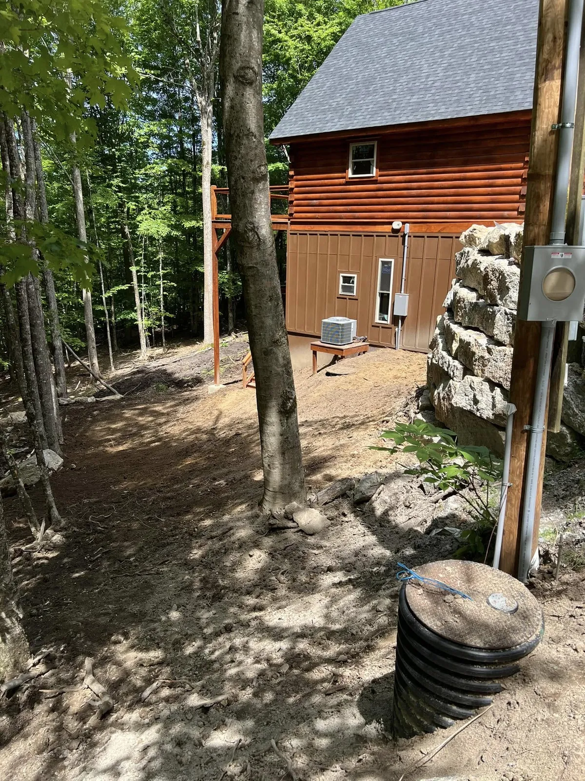 Septic pump basin set flush in the ground beside the home